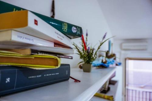 a stack of books sitting on top of a table at Casa con abbonamento parcheggio sul Lungomare in Gaeta