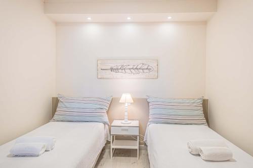 - 2 lits dans une petite chambre avec une lampe sur une table de nuit dans l'établissement Atlantic View com piscina, à Portimão