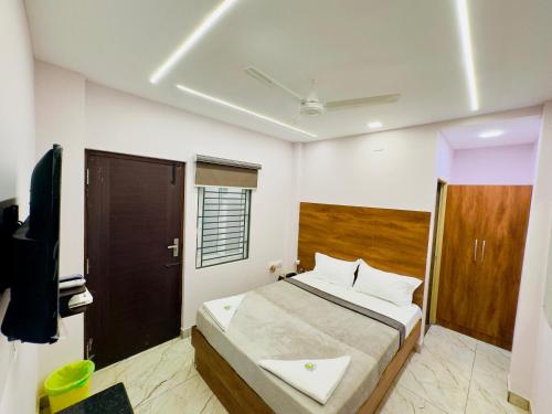 a bedroom with a bed and a tv in it at GREENS INN in Chennai