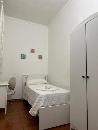 ein weißes Schlafzimmer mit einem Bett und einem Stuhl in der Unterkunft Giulia's House in Turin