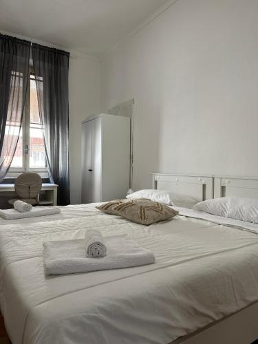 ein großes weißes Bett mit Handtüchern darüber in der Unterkunft Giulia's House in Turin