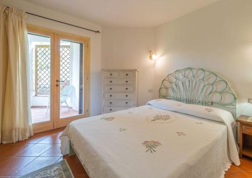 ein Schlafzimmer mit einem Bett, einer Kommode und einem Fenster in der Unterkunft Villa Zagara in Olbia