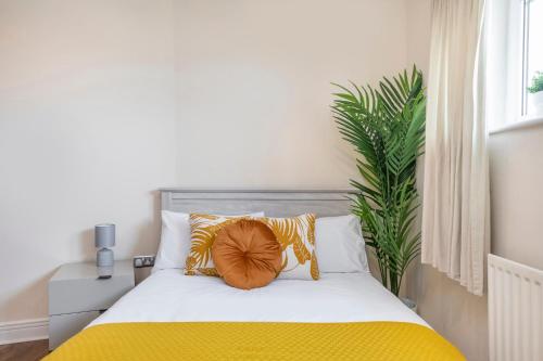 a bedroom with a bed with yellow sheets and a plant at River View 2 Bed 2 Bath Flat - London City Airport, Excel, Pontoon Dock in London
