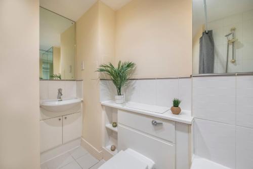 a white bathroom with a sink and a mirror at River View 2 Bed 2 Bath Flat - London City Airport, Excel, Pontoon Dock in London