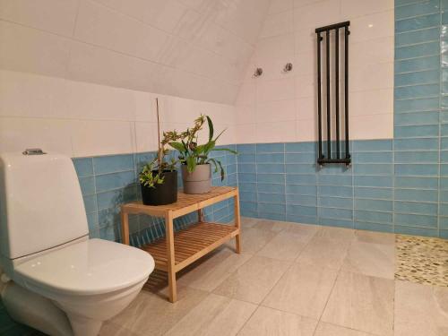 uma casa de banho com WC e azulejos azuis e brancos em Gula Villan em Gotemburgo