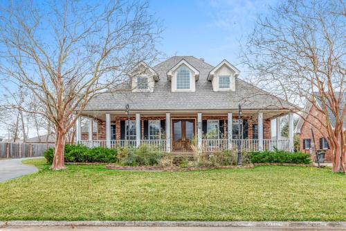 a brick house with a porch and trees at Lake Charles Luxe: Casino Escape in Lake Charles