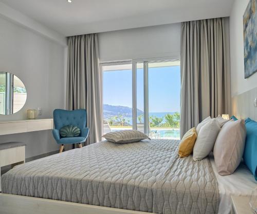 a bedroom with a large bed and a blue chair at Lefkimmiatis Villas Corfu in Afionas