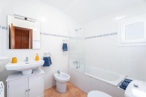 a white bathroom with a sink and a toilet at Antiga escola Pla del Sabater in Culla