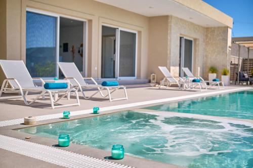 een zwembad met ligstoelen en een zwembad bij Lefkimmiatis Villas Corfu in Afionas