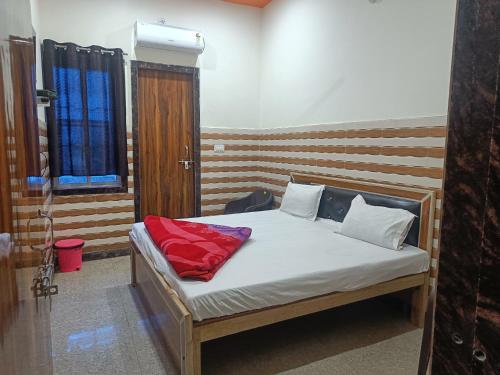 um quarto com uma cama com uma almofada vermelha em Babu seva em Govardhan