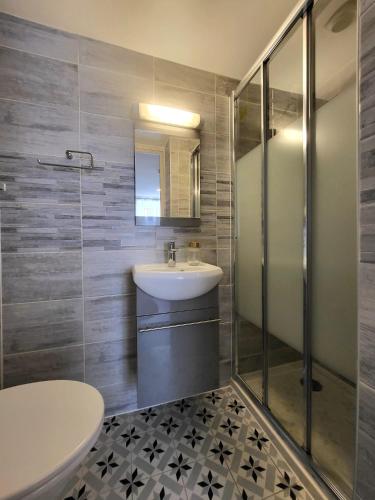 une salle de bain avec un lavabo et une douche dans l'établissement Hôtel Résidence A la Buttes aux Cailles, à Paris