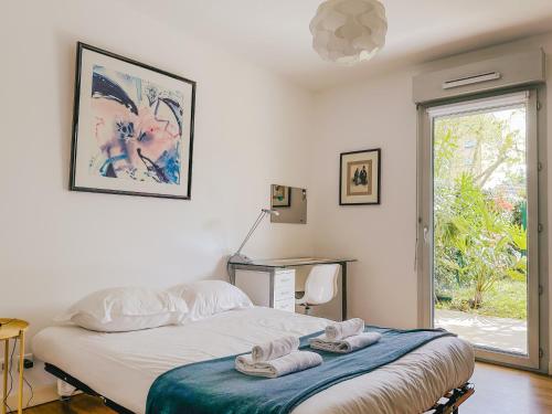 a bedroom with a bed and a desk and a window at Les Galets - Duplex avec jardin - 2 chambres et bureau in Pau