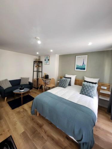 une chambre avec un grand lit et un salon dans l'établissement Hôtel Résidence A la Buttes aux Cailles, à Paris