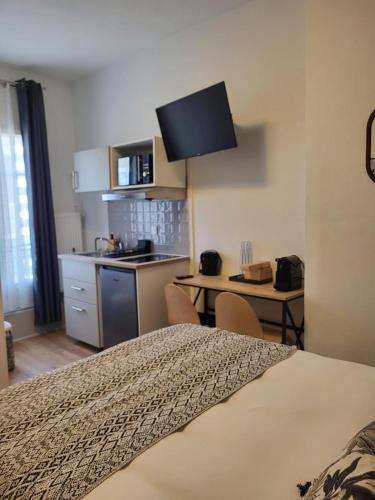 une chambre avec un lit et une cuisine avec une table dans l'établissement Hôtel Résidence A la Buttes aux Cailles, à Paris