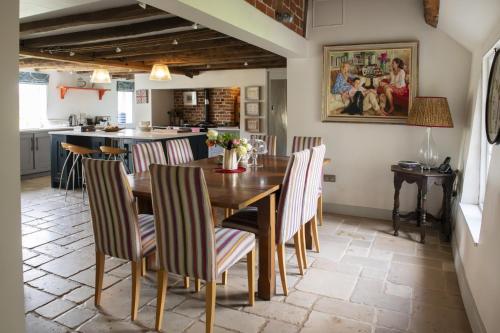 a kitchen and dining room with a wooden table and chairs at Fabulous Farmhouse in Hampshire in London