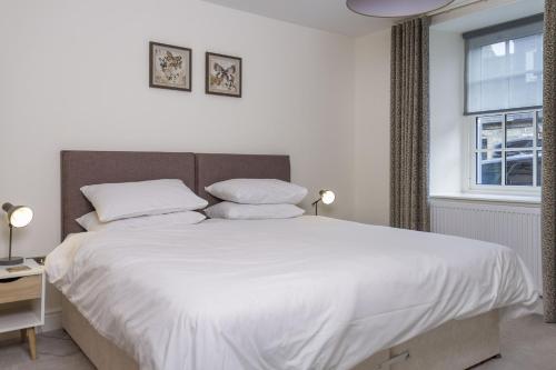 a bedroom with a large white bed with two pillows at Stroan in New Galloway