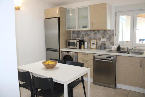a kitchen with a white table and a kitchen with a sink at Azinheira Villa - Grândola in Azinheira dos Barros