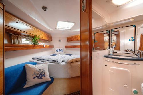 a small bathroom with a bed and a sink at Charming sailing boat - Le dimore di Ines in Bari