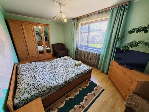 a bedroom with a bed and a chair and a window at Lavanda in Verkhovyna