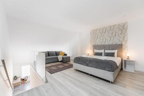 a white bedroom with a bed and a couch at GuestReady - Aveiro's Hidden Gem in Aveiro