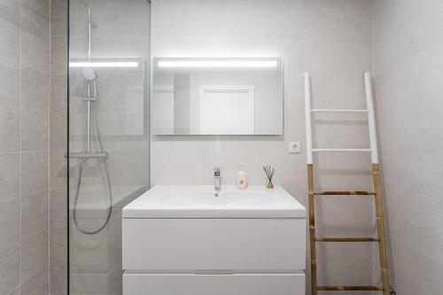 a white bathroom with a sink and a shower at GuestReady - A Slice of Aveiro in Aveiro