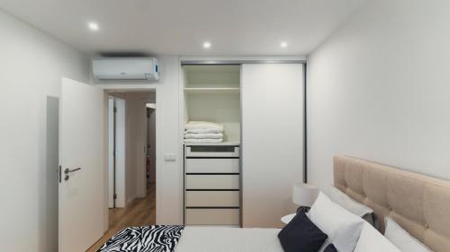 1 dormitorio con 1 cama y vestidor en GuestReady - Glamorous getaway in Coimbra en Coimbra