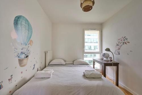 une chambre avec un grand lit et une fenêtre dans l'établissement Cosy appartement direct PARIS La Défense, à Rueil-Malmaison