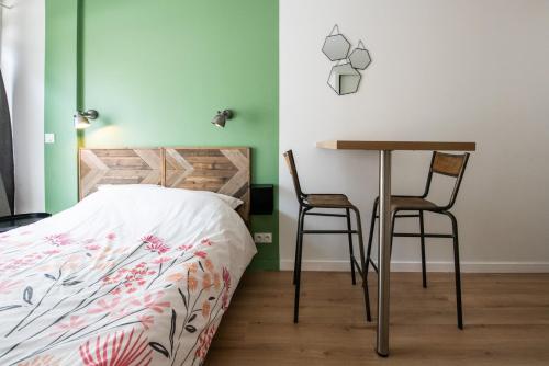 a bedroom with a bed and a table and two chairs at Central Part-Dieu - Appartement 1 in Lyon