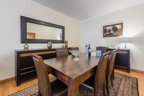 uma sala de jantar com uma mesa, cadeiras e um espelho em GuestReady - Espinho Lux no Porto
