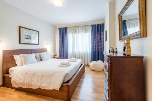 ein Schlafzimmer mit einem großen Bett und einem Fenster in der Unterkunft GuestReady - Espinho Lux in Porto