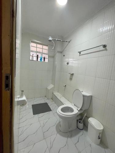 a white bathroom with a toilet and a tub at Ankar Homes, California 2 in Nanyuki