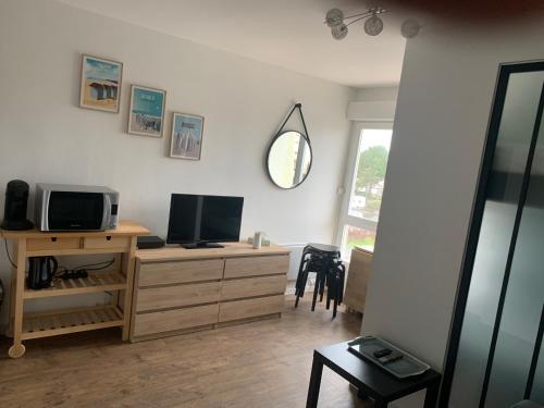 - un salon avec un bureau, une télévision et un miroir dans l'établissement Studio Bords de plage, à Saint-Jean-de-Monts