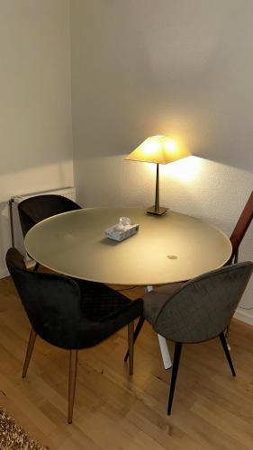 uma mesa com duas cadeiras e um candeeiro em Cost central flat em Aalborg