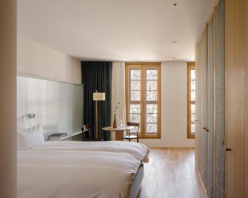 a hotel room with a large bed and a table at kleiner Löwe – Stadthotel Bregenz in Bregenz