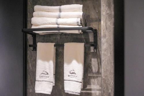 a towel rack with white towels on it at Shanming Boutique Homestay in Fenghuang