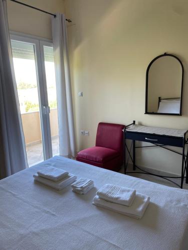 a room with a bed with three folded towels on it at Οικογενιακό διαμέρισμα in Mirina