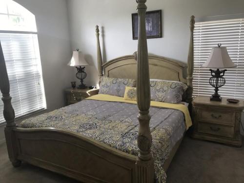 1 dormitorio con 1 cama y 2 mesitas de noche con lámparas en Lovely 4Bd Gm Spa Pool Hm Glenbrook-1616MSD, en Orlando