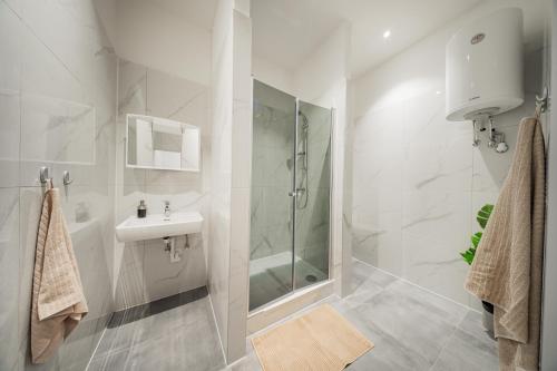 a white bathroom with a shower and a sink at SEVEN Rooms Vienna in Vienna