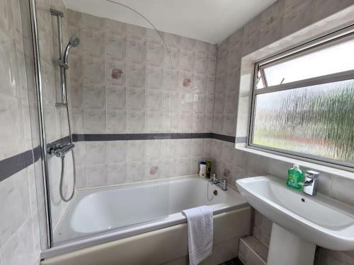 a bathroom with a bath tub and a sink at Paradigm Villa, Oxford,4 Bedroom, 4 Free Parking Spaces in Oxford