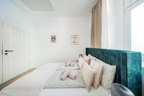 a bedroom with a bed with a green headboard and pillows at SEVEN Rooms Vienna in Vienna