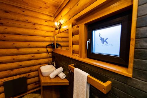 a bathroom with a television on a wooden wall at Kare Luxury Chalets in Tsigov Chark