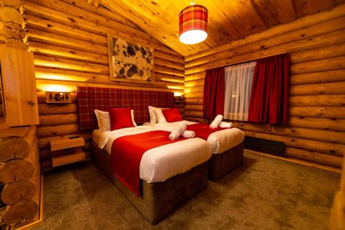 a bedroom with two beds in a log cabin at Kare Luxury Chalets in Tsigov Chark