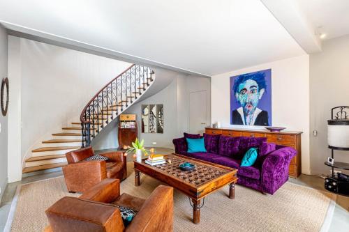 un salon avec un canapé violet et une table dans l'établissement GuestReady - Maison de Charme près de la Nature, à Boulogne-Billancourt