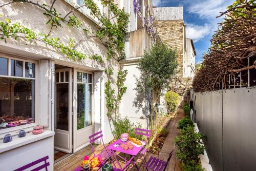 un patio avec une table et des chaises sur un porche dans l'établissement GuestReady - Maison de Charme près de la Nature, à Boulogne-Billancourt