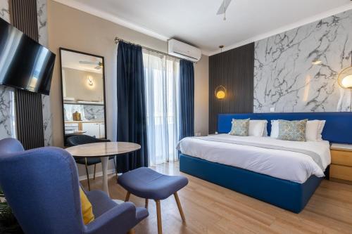 une chambre d'hôtel avec un lit, une table et des chaises dans l'établissement Park Lane Boutique Aparthotel, à San Pawl il-Baħar
