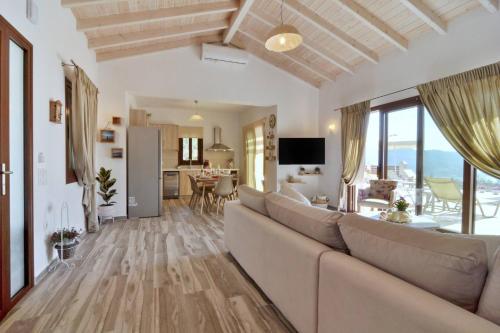 a living room with a large couch and a kitchen at Lefkimmiatis Villas Corfu in Afionas
