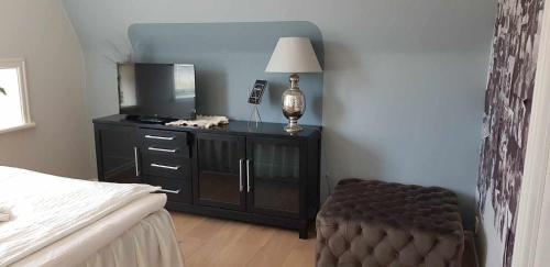 a bedroom with a bed and a tv and a chair at Gula Villan in Gothenburg