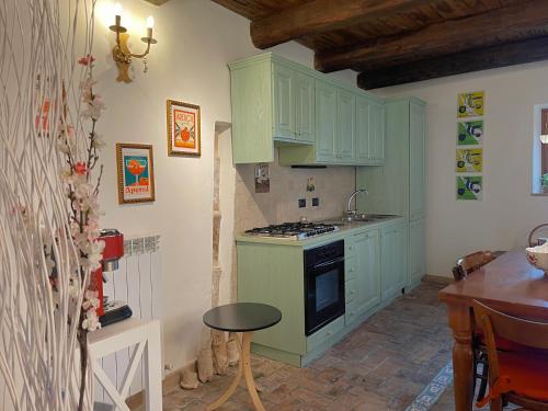 kuchnia z zielonymi szafkami i kuchenką piekarnik w obiekcie La Casa di LucaPietro Dimora Storica w mieście Spoleto