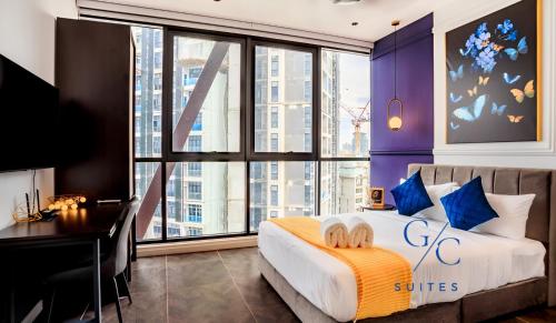 a bedroom with a bed with a desk and a large window at Scarletz KLCC luxury suites by GC-Suites in Kuala Lumpur