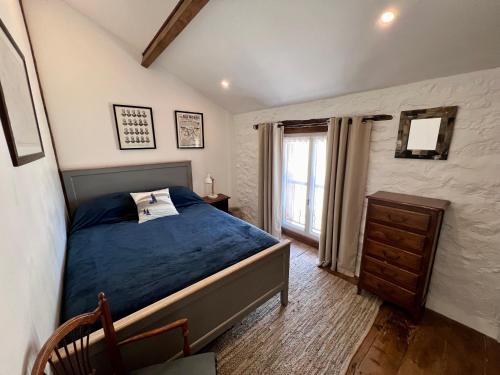 - une chambre avec un lit bleu et une fenêtre dans l'établissement Gite Marie Ange, à Marsac